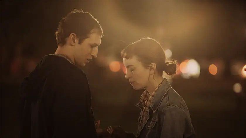 A man and a woman stand in front of each other looking sad in the film Darkest Miriam