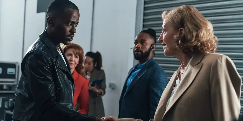 The doctor shakes a woman's hand in season 1 episode 7 of Doctor Who (2024), with some characters in the background