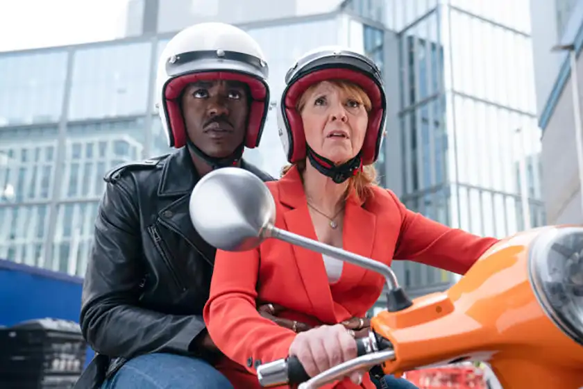 Two people are on a motorbike wearing helmets in Doctor Who episode 8, in a photo feature on Loud and Clear's review of the episode