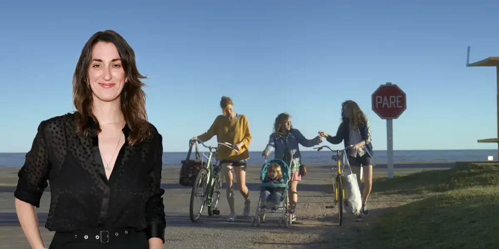 The outline of director Leticia Jorge over a still from her film, Don’t You Let Me Go, where three people walk with their bikes, used in a Loud and Clear interview
