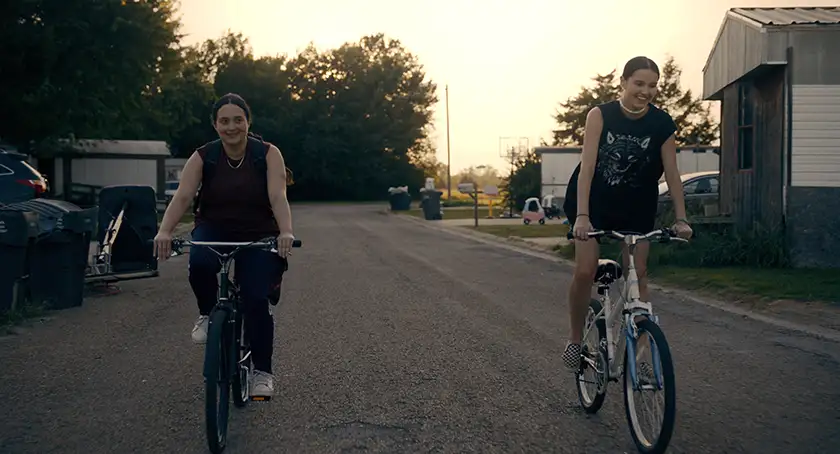 Two girls cycle down the road in the film Fancy Dance