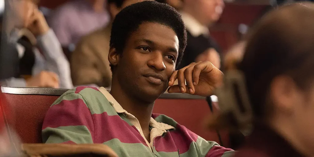 A Black boy sits wearing a striped t-shirt and smiling in the film Rob Peace