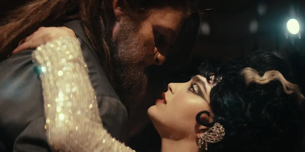 A woman with heavy makeup and a man dressed as a beast with a beard dance in the film Your Monster