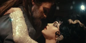 A woman with heavy makeup and a man dressed as a beast with a beard dance in the film Your Monster