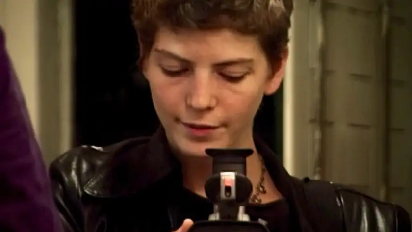 A woman looks down into a videocamera in a still from the film Fragments of a Life Loved