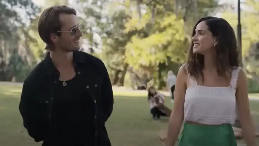 A man and a woman walk in a park looking at each other and smiling in the 2024 film Hit Man, one of the Top 10 Best Movies of 2024 So Far according to Loud and Clear Reviews