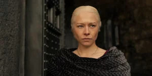 A woman with blond hair stands next to a door in season 2 episode 3 of House of the Dragon, from a photo featured on Loud and Clear's review and recap