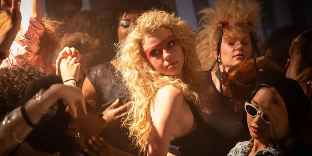 A woman with blonde hair dances in a club in the film MaXXXine