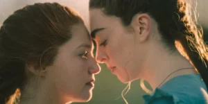 Two women stand in front of each other looking at one another, their faces very close, in the short film Sister Wives (2024)