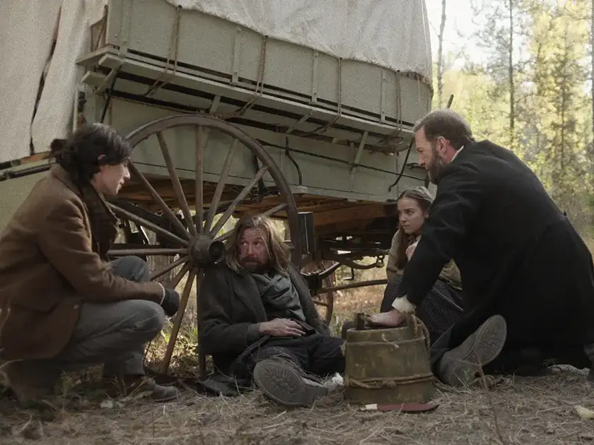 Three men and a girl lean against a carriage in the 2024 religious horror film Thine Ears Shall Bleed