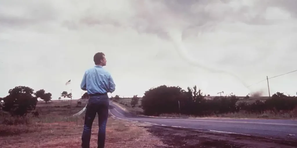 A man observes a tornado in the movie Twister (1996)