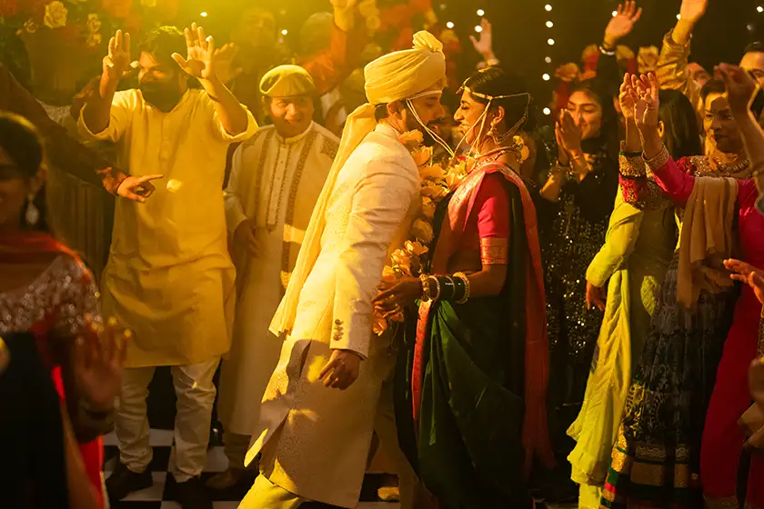 A man and a woman dance at a weeding in a crowd in A Nice Indian Boy