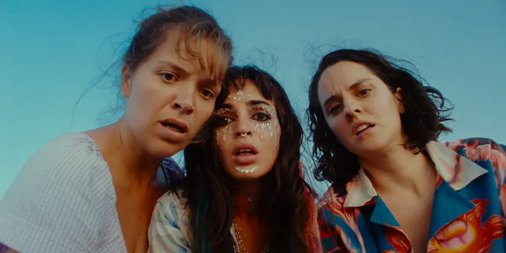 Three women stare at the camera in a still from The Balconettes