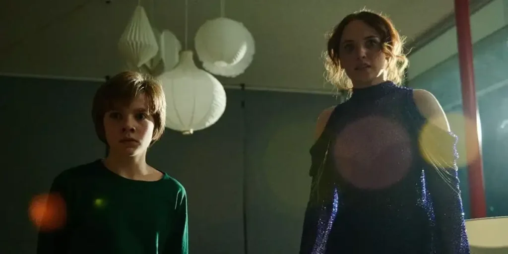 Two women look at the camera with baloons behind them in a still from Daddy's Head