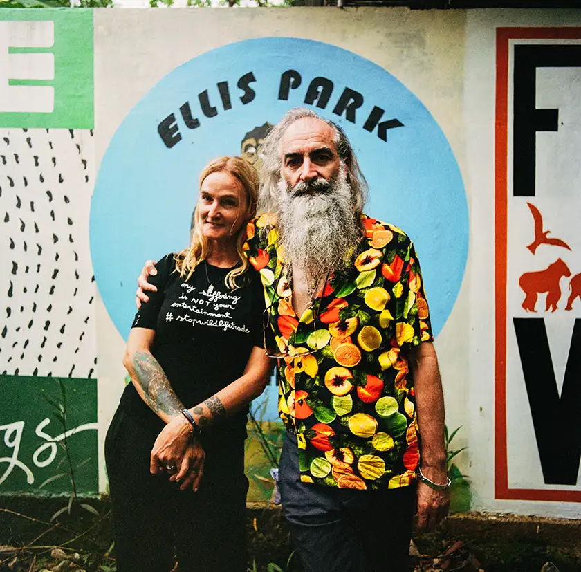 Warren Ellis and Femke den Haas pose for a photo in front of the Ellis Park sign in a still from the film Ellis Park, whose director, Justin Kurzel, we interview in this article