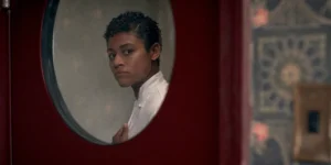 Ariana DeBose looks through the oval shaped door of a restaurant kitchen in the film House of Spoils