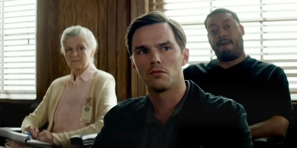 Nicholas Hoult looks to his left while sitting in a courtroom as a member of the jury in the Clint Eastwood film Juror #2