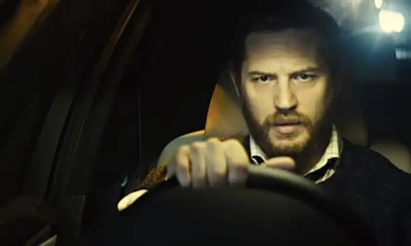 Tom Hardy drives a car as Ivan Locke in a still from the film Locke, whose complex morality is analyzed in Loud and Clear's article