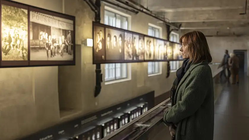 A woman looks at some photographs on the wall of a museum in Marco, the Invented Truth