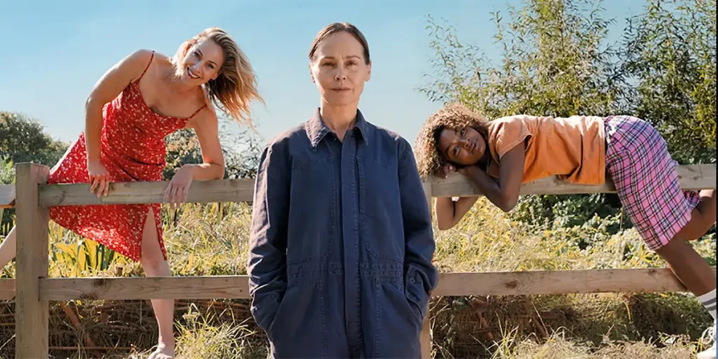 A woman stands in the middle of the shot with two women emerging from the sides in a still from the film Portraits of Dangerous Women