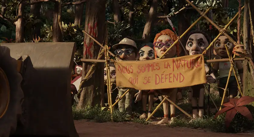 The characters of Savages (Sauvages) hold up a sign that reads "We are nature defending itself" in a still from the film