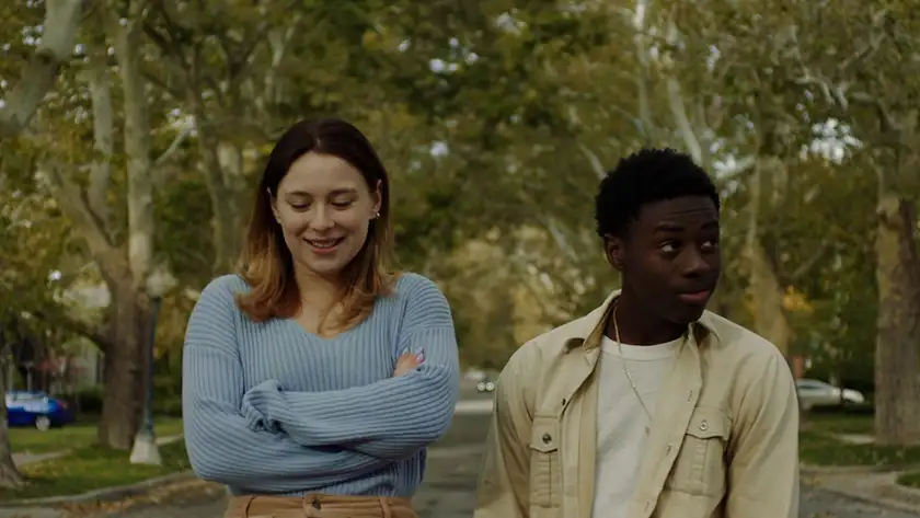 A young woman and a young man walk in a park in a still from the film The Graduates