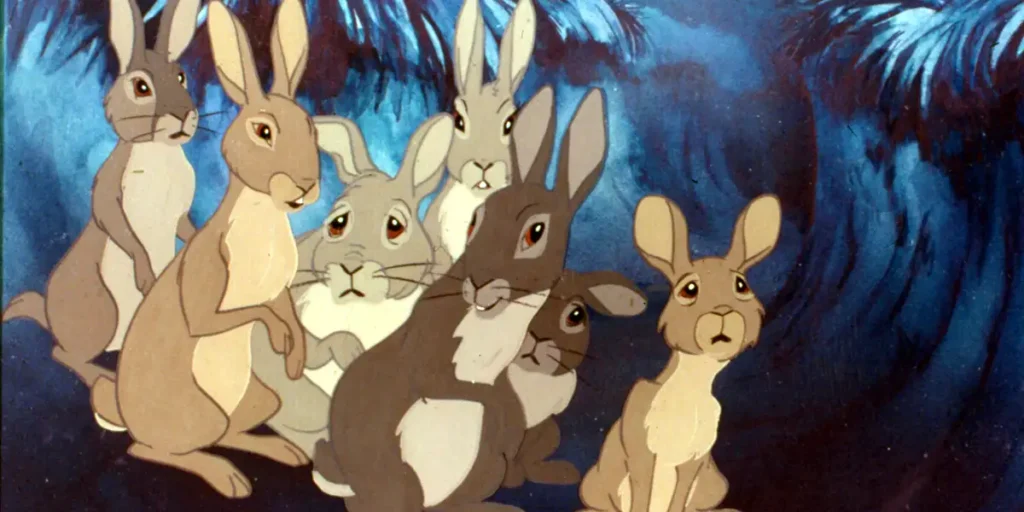 Many animated bunnies look scared in a cave in a still from the 4K restoration of Watership Down