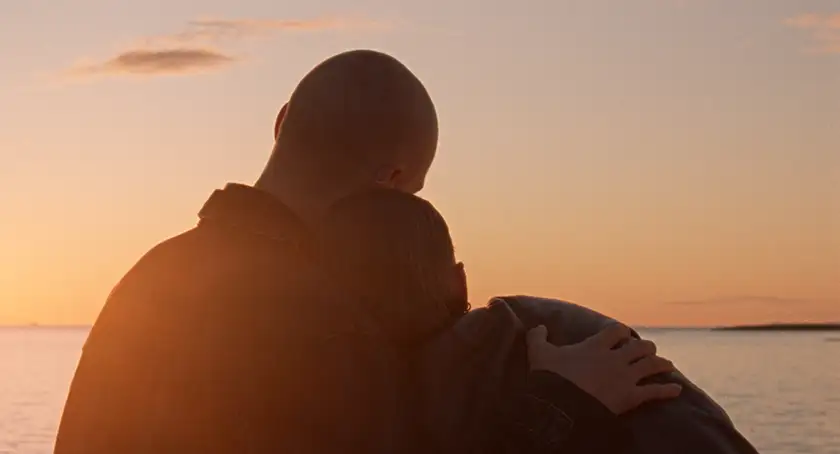 Mikael Kaaber and Elín Hall hug each other by the beach at sunset in When the Light Breaks, whose director, Rúnar Rúnarsson, we also interview