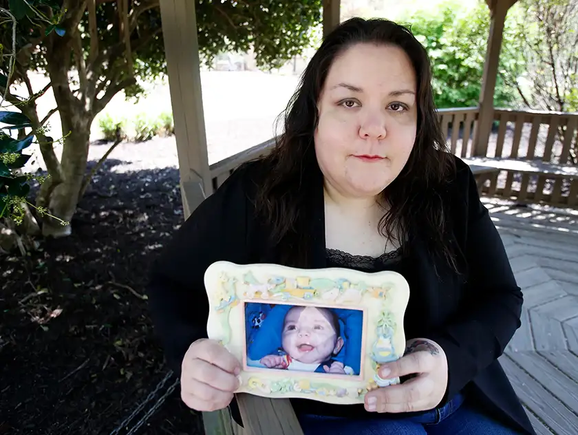 Alyssa Pladl holds a photo of her daughter Katie, in a still featured in an article about her true story, recounted in the thriller Husband, Father, Killer