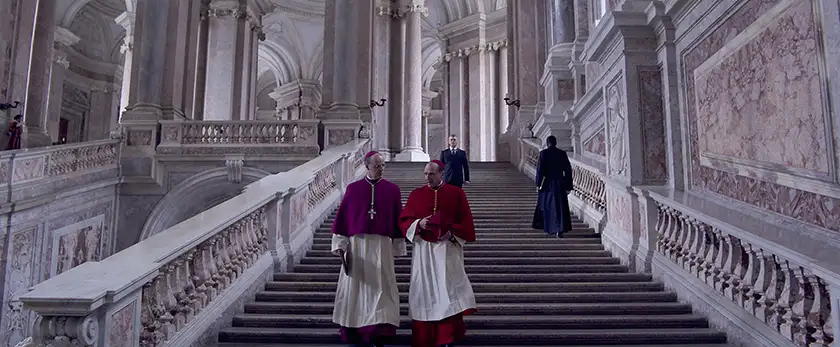 (L to R) Brían F. O’Byrne as Cardinal O’Malley and Ralph Fiennes as Cardinal Lawrence in director Edward Berger’s Conclave, whose producer, Michael Jackman, we interview