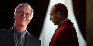 Producer Michael Jackman, whom we interview, and a still of Ralph Fiennes dressed as a cardinal in the film Conclave