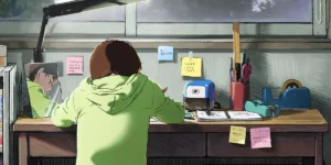 A girl wears a green hoodie and draws in a still from the 2024 movie 'Look Back'