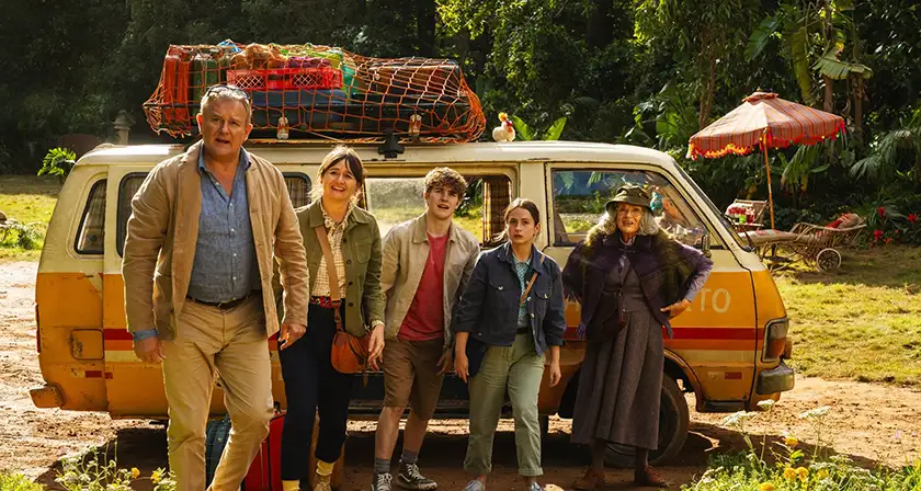 The Browns pose in front of a yellow van in a still from the 2024 film Paddington in Peru