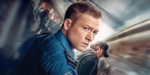 Taron Egerton looks back dressed as an airport officer as Ethan Kopek in Carry-On