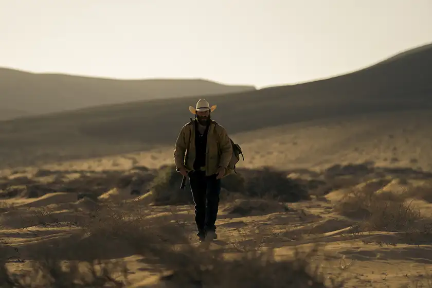 Jay walks in the desert in a still from the movie Catching Dust