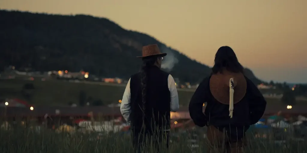 Two indigenous men look at the mountains in a still from the film Sugarcane