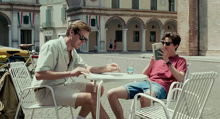 Two boys sit at an outdoors table in Italy in Call Me By Your Name