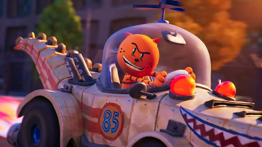 An orange cat named Petey (Pete Davidson) drives a t-rex car in DreamWorks Animation’s Dog Man (2025)