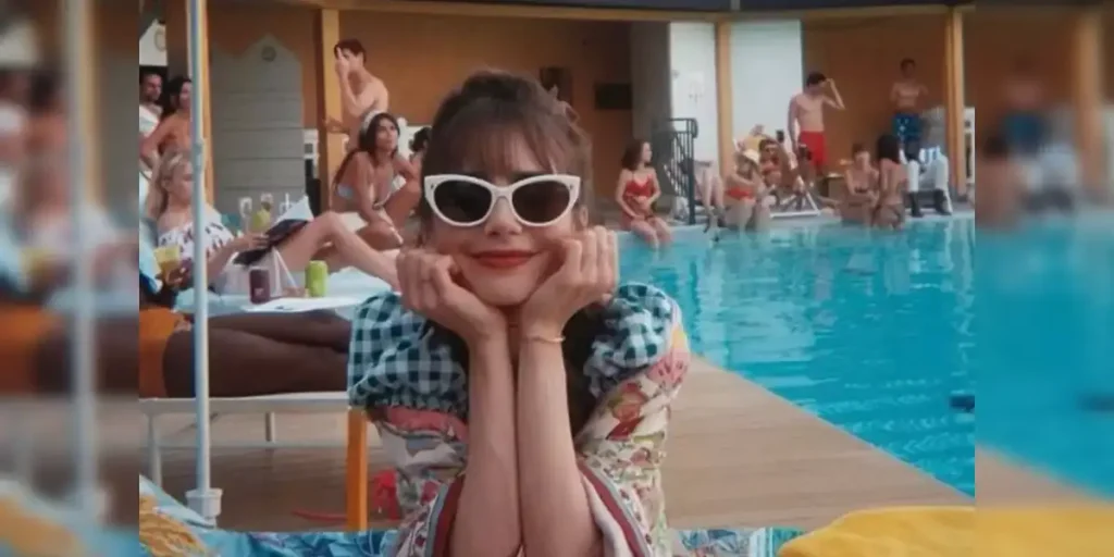 Emily in Paris sits by the pool wearing white glasses