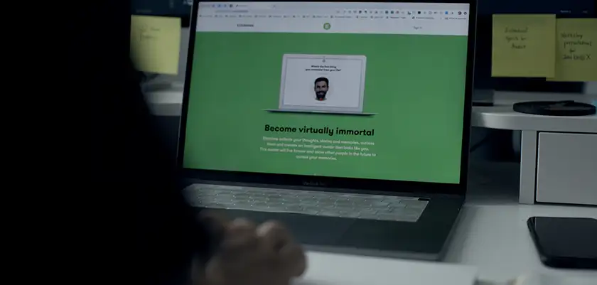 A computer screen has a green advert that reads "become virtually immortal" in a still from the 2025 film Eternal You