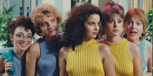 Three women look to their left and two women look at the camera in Golden Eighties