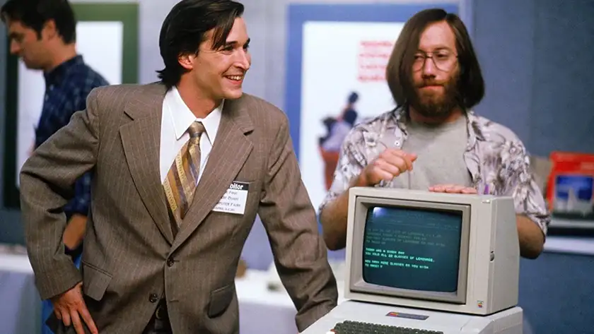 Two men stand behind a computer in Pirates of Silicon Valley