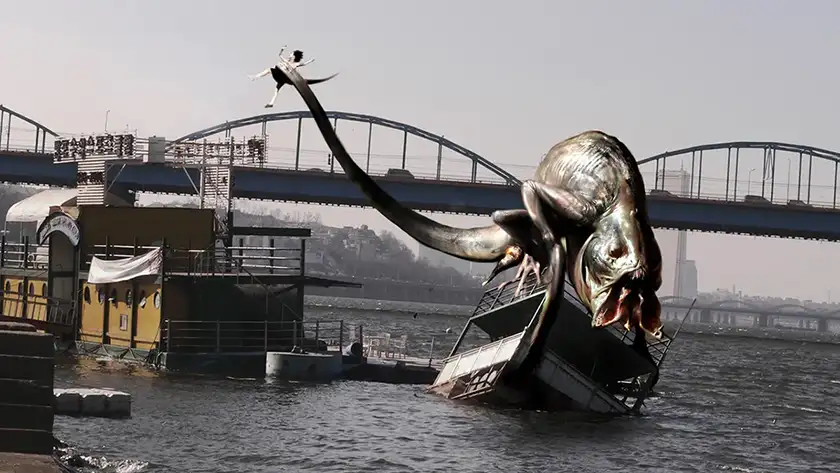 A giant water monster leans on a boat in The Host