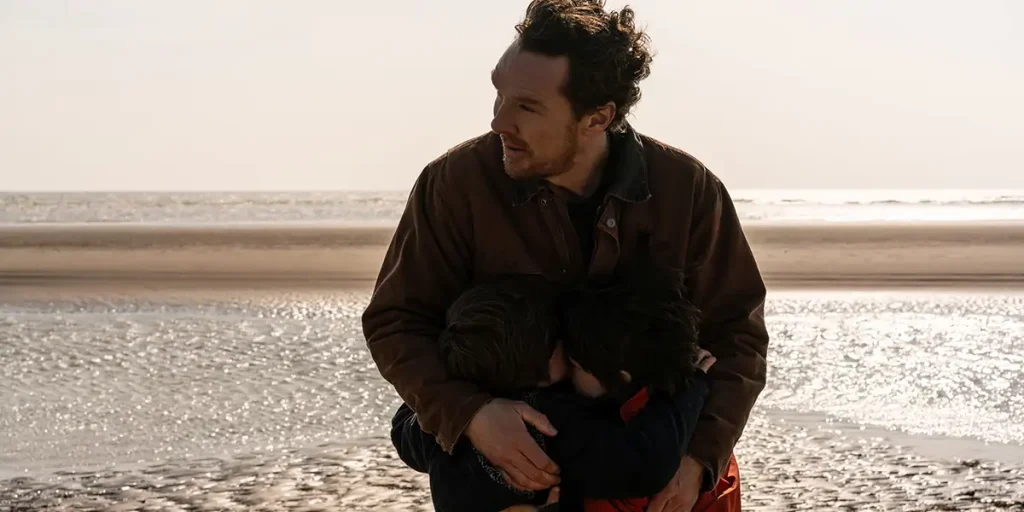 Benedict Cumberbatch hugs two children on the beach in The Thing with Feathers by Dylan Southern