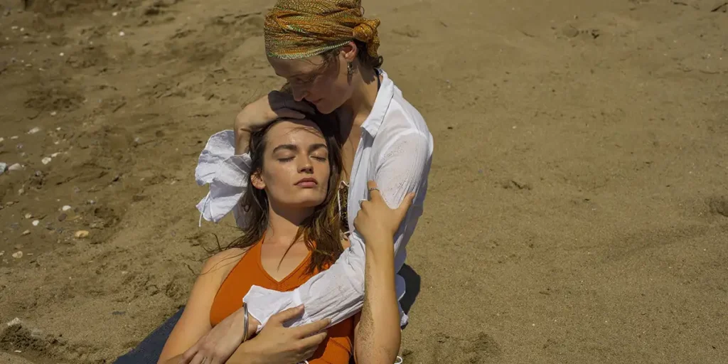 Vicky Krieps and Emma Mackey hug on the sand in Hot Milk by Rebecca Lenkiewicz