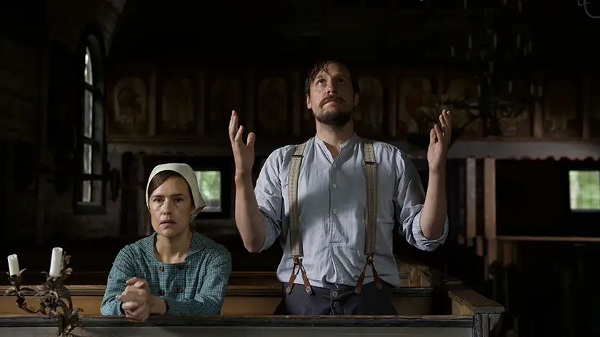 A man and a woman pray in a church in a still from the movie Raptures (Rörelser)