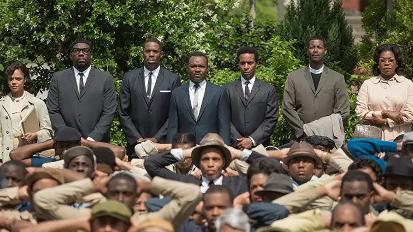 Men and women stand while other men sit on the floor in front of them with raised arms in the film Selma, one of all 8 2015 best picture nominees ranked from worst to best by Loud And Clear Reviews