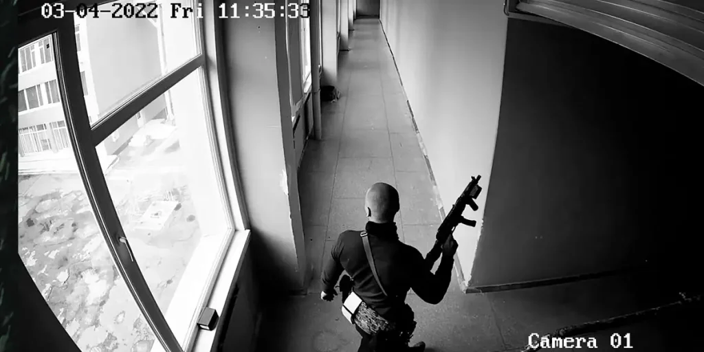 A Russian soldier holds a rifle on CCTV in a black and white still from Special Operation (Spetsialna Operatsiia)