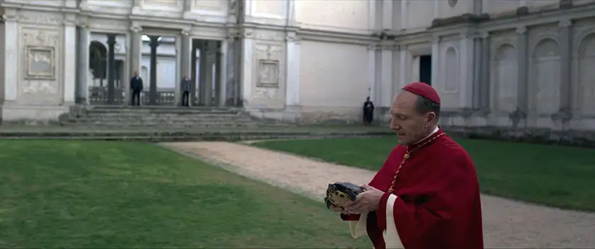 Ralph Fiennes holds a turtle in a still from the movie Conclave, whose ending, meaning and symbolism are explained in this article