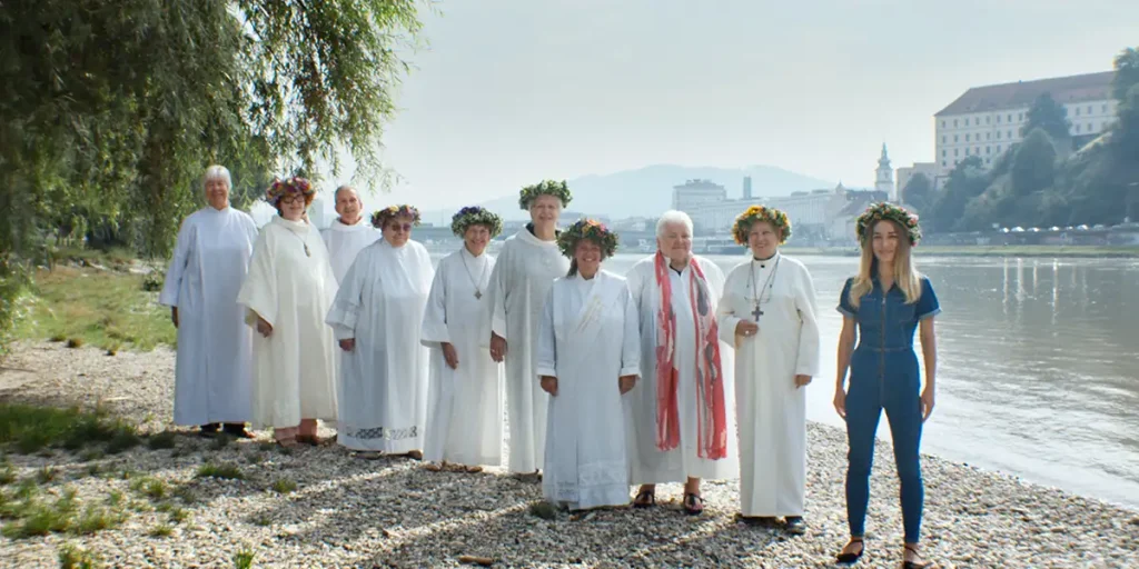 People stand dressed in white robes in a still from the CPH DOX movie Girls & Gods